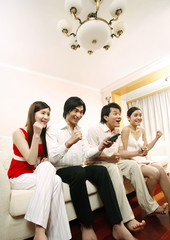 Men and women watching television in the living room