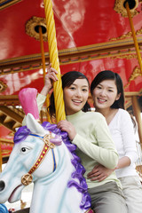 Fototapeta na wymiar Women riding on carousel