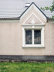 A white gabled window in a beige wall, vilnius, lithuania