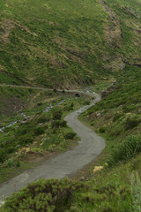 Fototapeta na wymiar Winding paved road in mountains. From above of rural curved road in hilly area