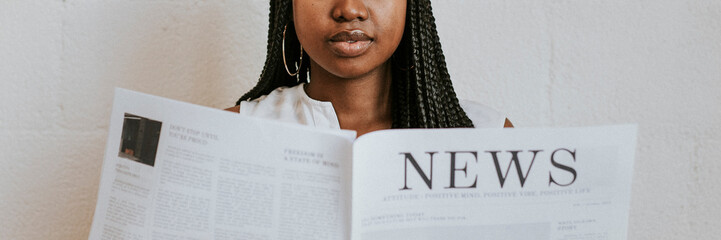 Black woman reading a newspaper - Powered by Adobe