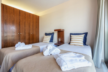 Fototapeta na wymiar Bedroom with a modern bed and towels in foreground. European hotel design. 