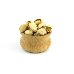 Pistachios in wood bowl close up isolated on white background.