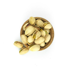 Pistachios in wood bowl close up isolated on white background.