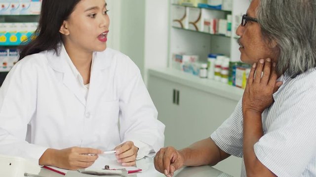 Beautiful asian Pharmacist counseling medication to patient in drug store
