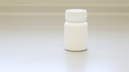 Mock up white medicine bottle or jar with cap template isolated in white medical room background, medicine packaging for medication pills, tablets, capsules drug pharmaceutical or Supplement vitamin.