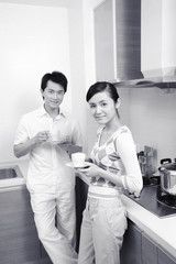 Man and woman with cups of coffee smiling at the camera