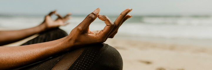 Black woman meditating on the beach