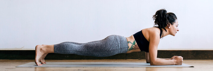 Sporty woman doing yoga in the room