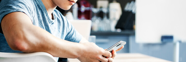 A man using a smartphone in a cafe