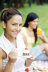 Two women having picnic at the park, focus on woman in front