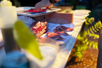 Friends making barbecue in the evening at a party
