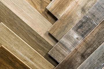 Variety of wooden like tiles. Samples of fake wood tiles for flooring. Assortment of floor laminate / tiles in an interior shop. - Powered by Adobe