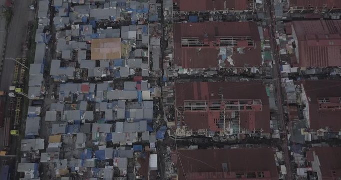 Ungraded, Descending bird's eye view aerial flight over slums tilting up revealing busy street. Drone, 4K. 