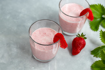 Strawberry and yogurt smoothies on a gray background. Decorated with elderberry flowers and strawberries. Healthy nutrition, diet.