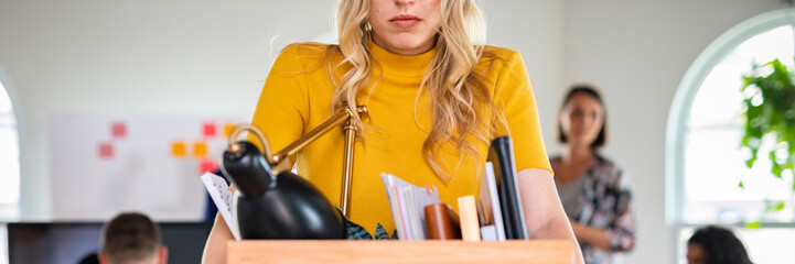 Young businesswoman carrying a wooden box