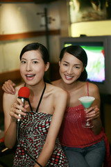 Women having fun in karaoke lounge
