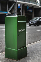 Naklejka premium Public mailbox in the street with a blurred car in background.