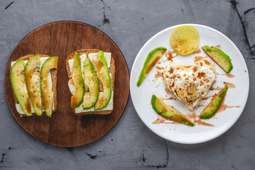Beautiful healthy romantic Breakfast of fried eggs in the shape of a heart on a white plate and avocado sandwiches