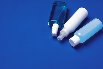 Bottles with antibacterial hand sanitizer on blue background with copy space