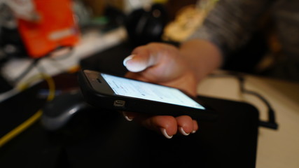 A woman holds a phone in her hand