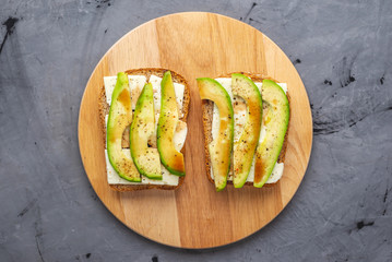Healthy vegetarian sandwiches with sliced avocado and tofu cheese. Modern and simple Breakfast. Top view