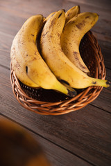 Bananas in a basket on a wooden brown natural background