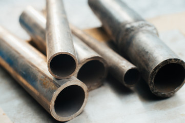 Stainless steel scrap metal, stainless steel pipes on the background of a stainless steel sheet....