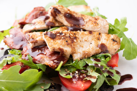 A chicken salad with rucola bacon and tomato