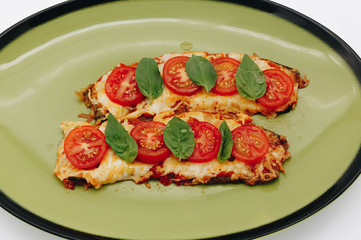 Chicken chop with tomatoes, cheese and basil on a white background