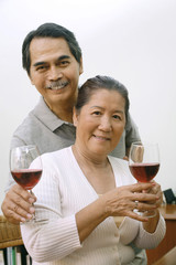 Senior man and woman holding wine glasses