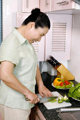Senior woman cutting vegetables in the kitchen