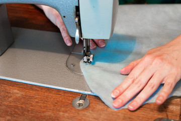 sewing medical protective clothing with a foot sewing machine, sewing shoe covers from medical blue fabric,