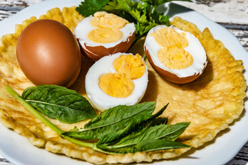 Boiled chicken eggs with two yolks in a cut on a pancake.