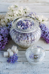Obraz na płótnie Canvas Lilac flowers and sugar in a glass jar
