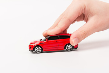 Red toy car  in hand  isolated on white background