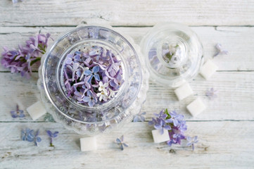 Lilac flowers and sugar in a glass jar