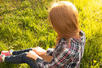 Girl teenager reads book outdoor