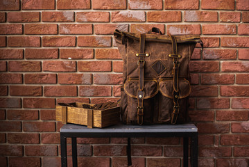 vintage canvas backpack near brick wall © VlaDee