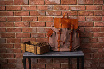 vintage canvas backpack near brick wall © VlaDee
