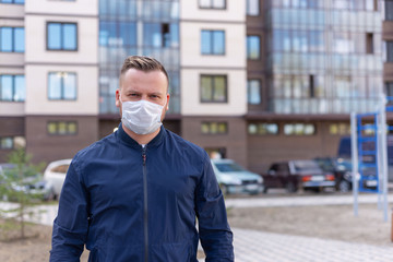 Concept of kovid 19. portrait of a Caucasian man on the street in the city. wearing a medical mask and gloves to prevent the rapid spread of the corona virus.keeping a safe distance
