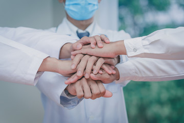 Doctors join hands together,Doctors and nurses in a medical team stacking hands stop coronavirus-19 outbreak.