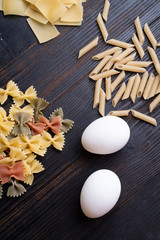 recipe of italian pasta on dark wooden table. dry pasta background