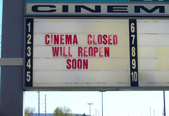 A sign for an American mall multiplex movie theater closed during the Covid-19 outbreak says Cinema Closed Will Reopen Soon in the Spring of 2020