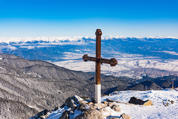 wooden christian cross on top of a mountain
