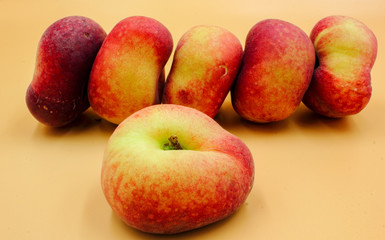 panoramic closeup of ripe fresh fruit  flat peaches in a row isolated with nobody