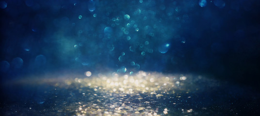 background of abstract glitter lights. gold, blue and black. de focused