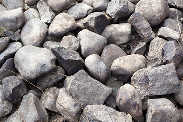 Gray stone closeup. Stone texture. Scattered gray cobblestones. Stone path background above. Gravel. 
Stone wall background. Many stones. Crushed. construction rocks. Building material. 