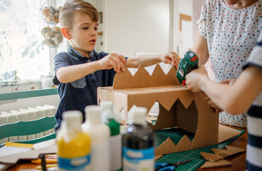 Mom and kids making a cardboard dinosaur costume