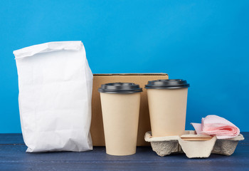 brown paper disposable cups with a plastic lid stand in the tray